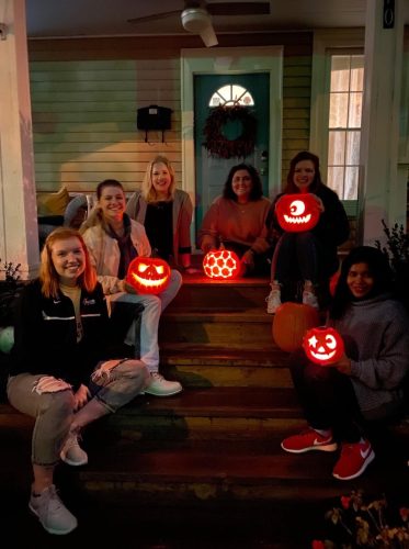 students hold pumpkins that they carved for Halloween